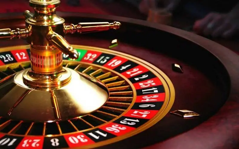 Close-up of a brass roulette wheel turret with red and black numbered pockets around it